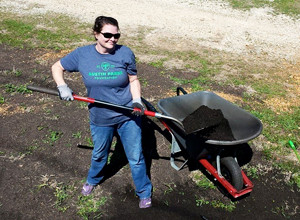 member adding compost to plot